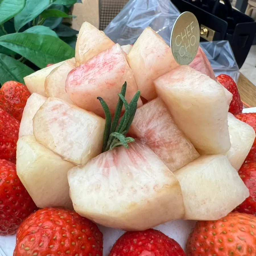 Top of Peach Berry cake piled high with peach and strawberry
