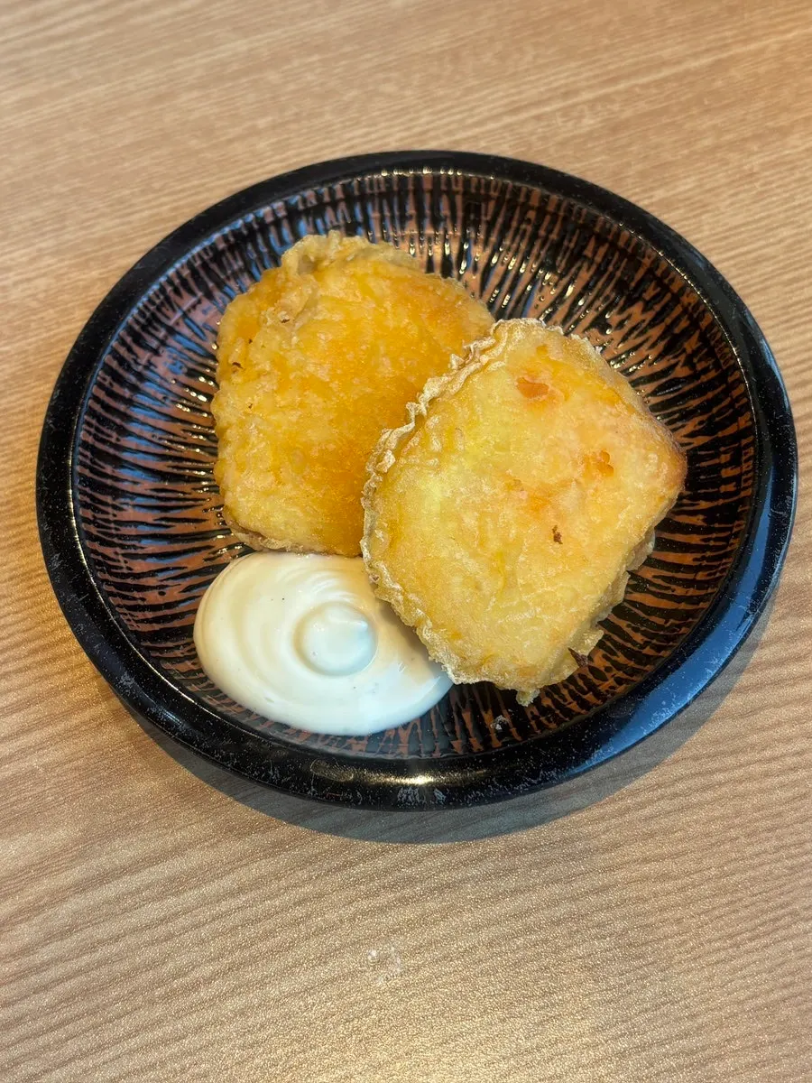 Freshly fried sweet potato fritter served before the meal
