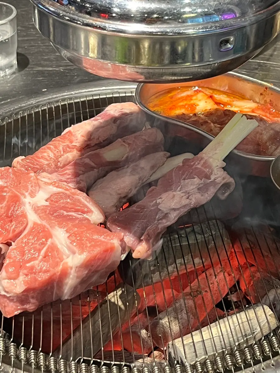 직원이 숯불에 고기를 구워주는 모습