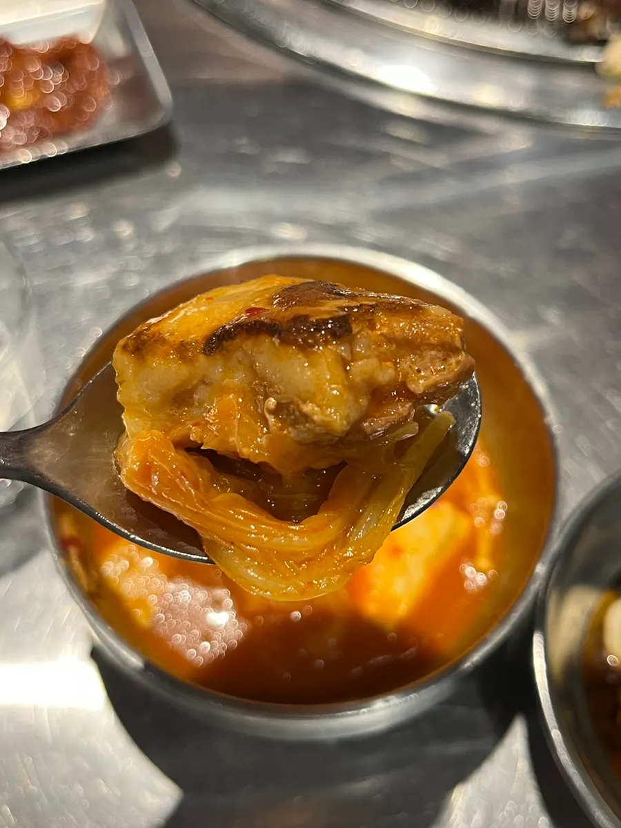 큼지막한 돼지고기가 든 김치찌개 한입
