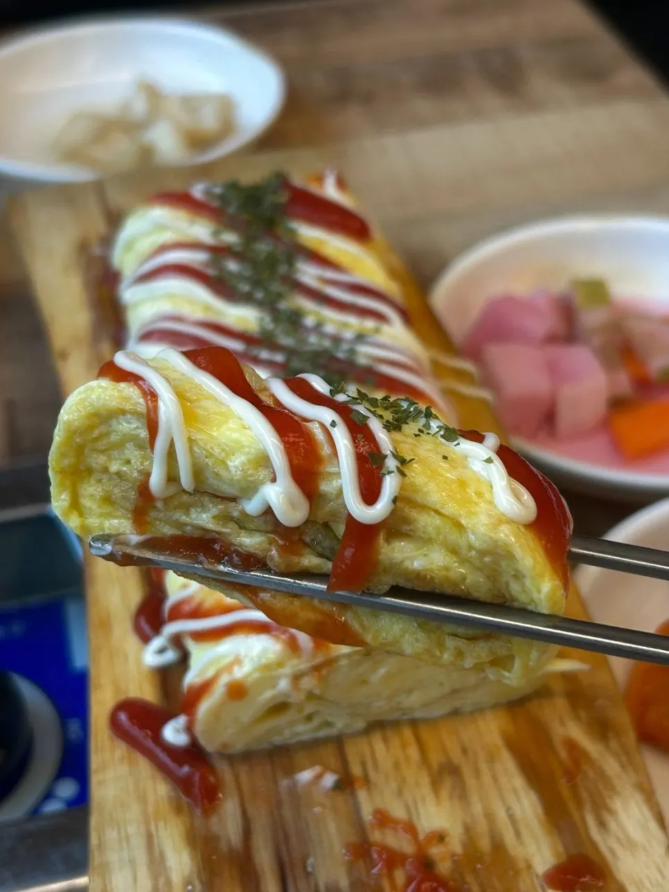 Thick rolled omelet drizzled with ketchup and mustard