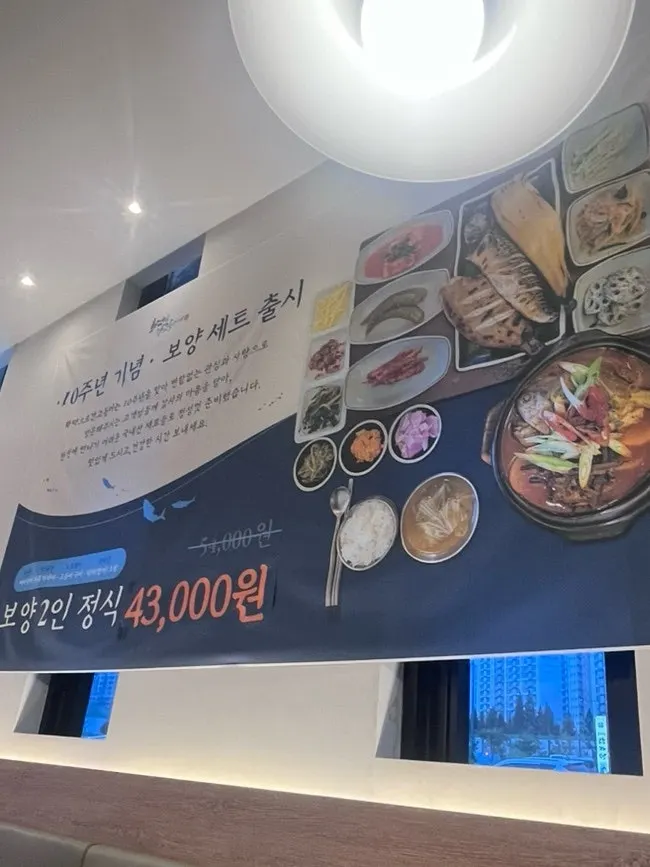 Menu board listing grilled fish sets and marinated crab