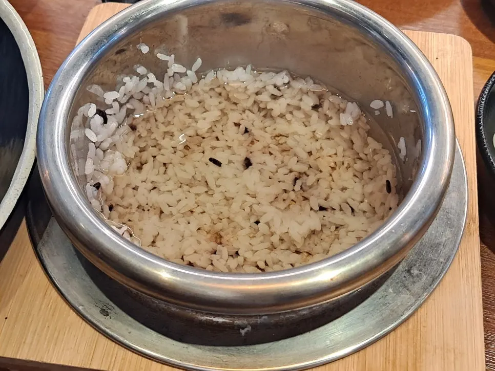 Pouring barley tea into the pot after removing the rice