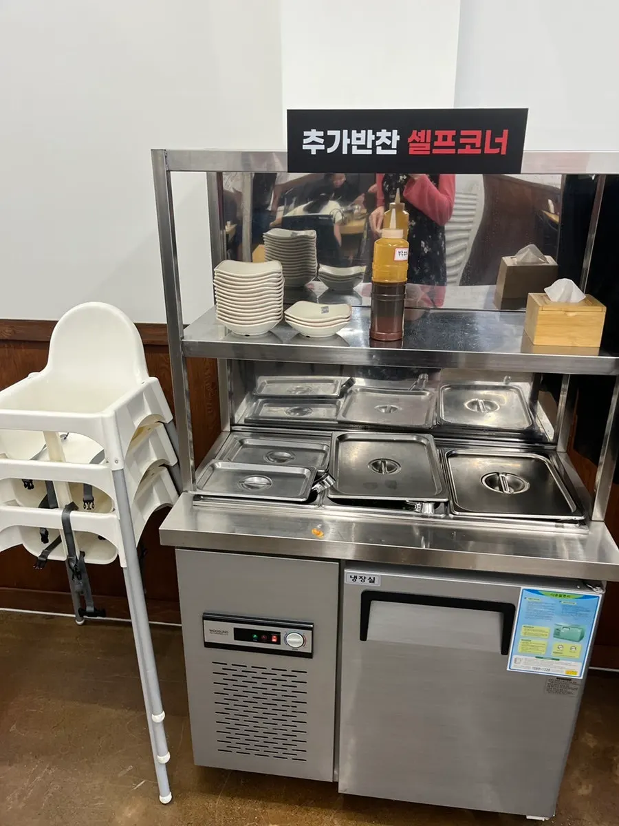 Self-serve side dish bar with a baby chair placed next to it