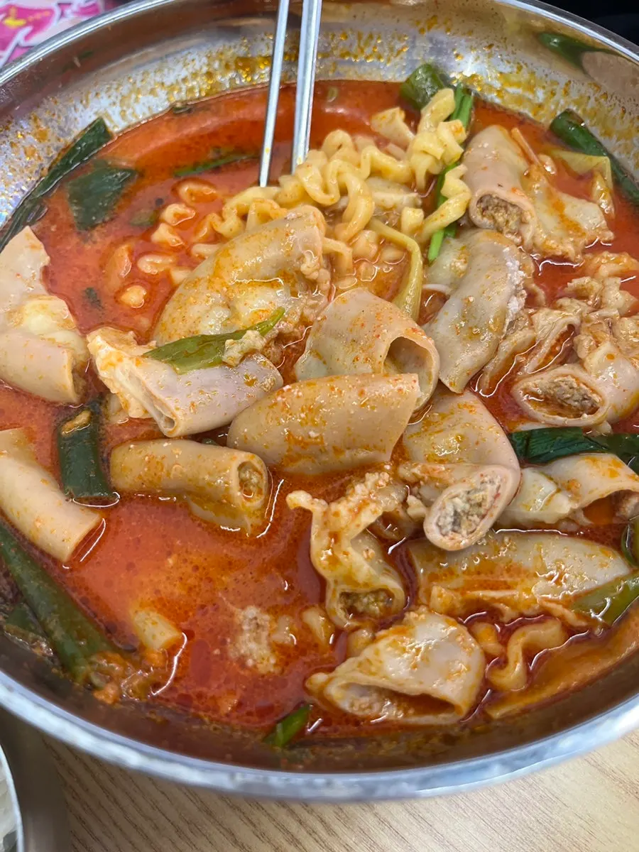 A piece of gop-filled wang gopchang picked up with chopsticks