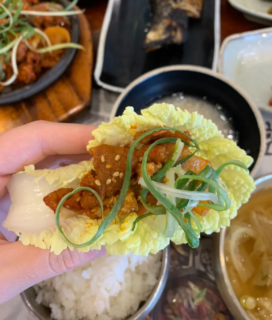 쌈 채소에 제육볶음과 반찬을 올린 모습