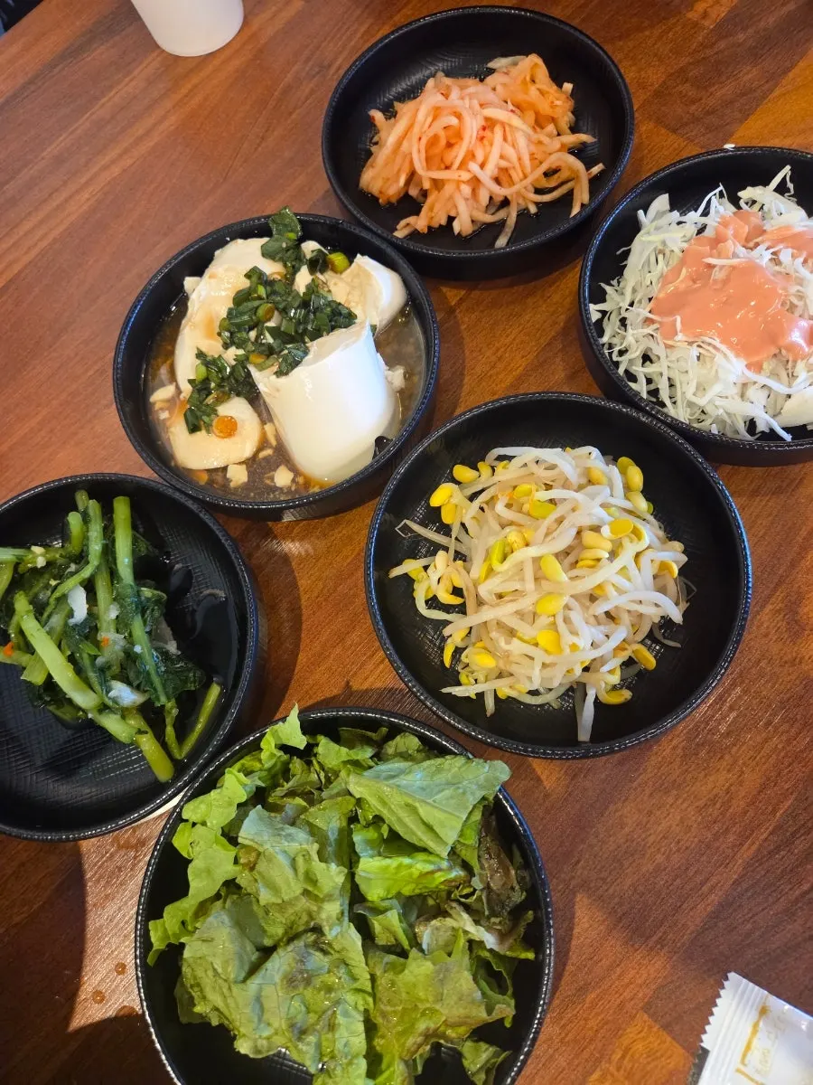 Table setting with young radish kimchi, lettuce, and other basic side dishes
