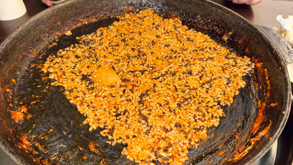 A bite of dakgalbi on a piece of pickled radish