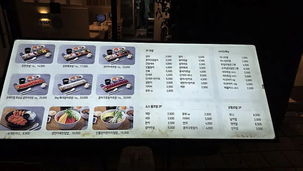 Sushi prices listed on the entrance menu board