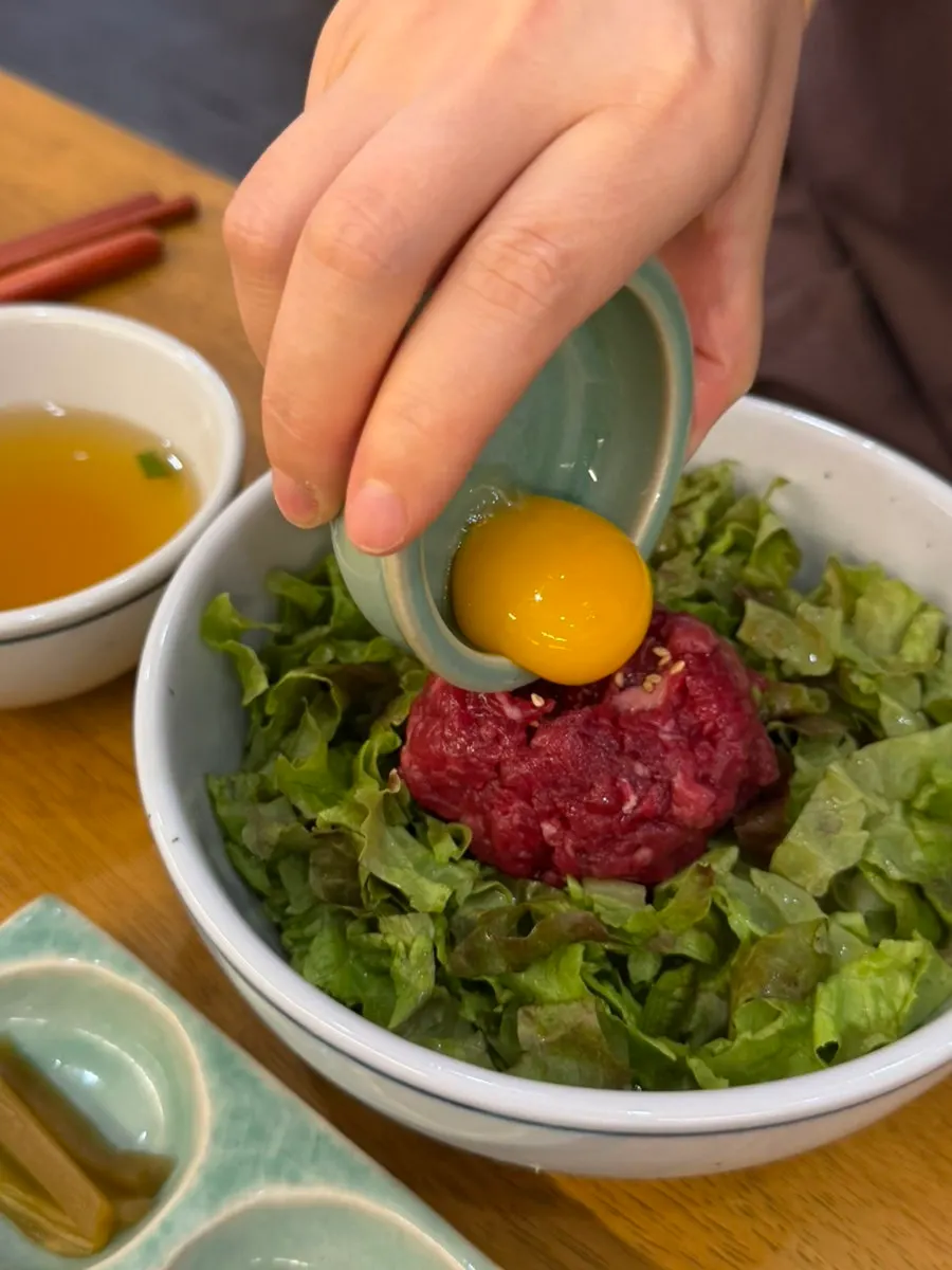 Egg yolk placed on top of the yukhoe bibimbap