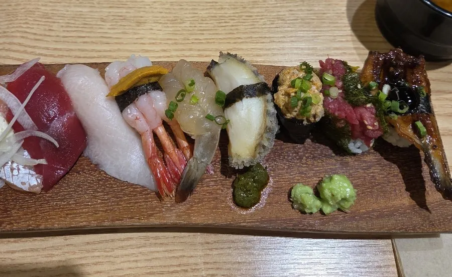 A long spread of 12 pieces of sushi
