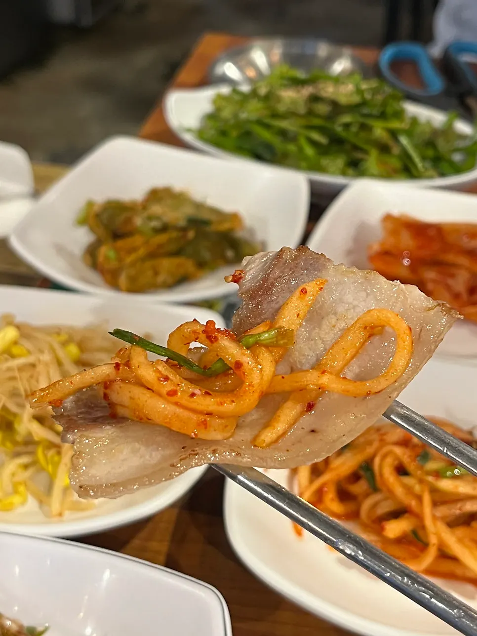 Mesa familiar con samgyeopsal y platos de comida juntos