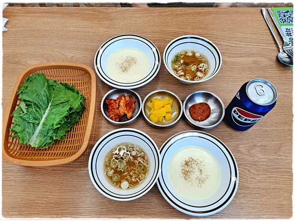Table spread with lettuce-wrap vegetables and soup