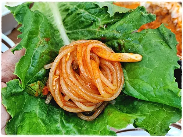 Chewy spicy noodles eaten with lettuce-wrap vegetables
