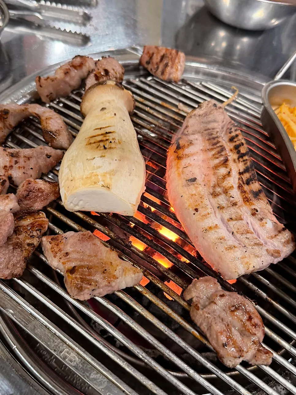 A grilled slice of pork belly dipped in salt