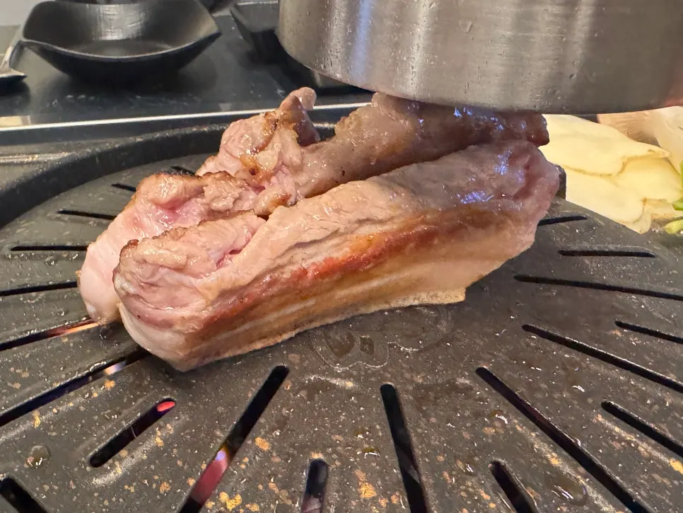 Staff grilling the pork belly for guests