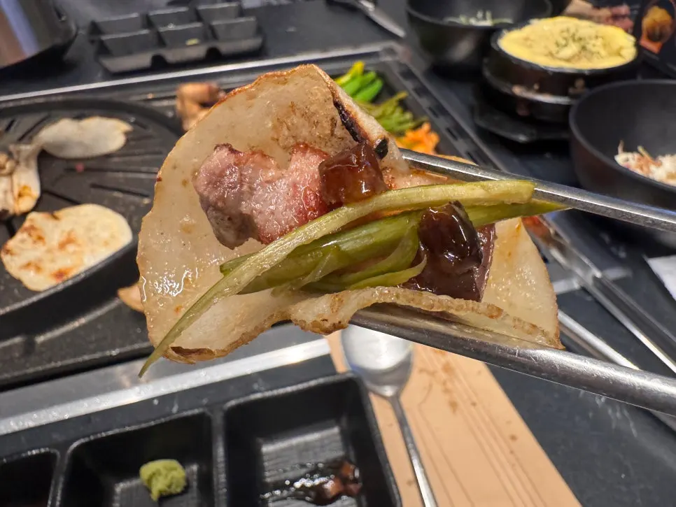 Signature wrap of potato slice topped with meat and garlic scapes