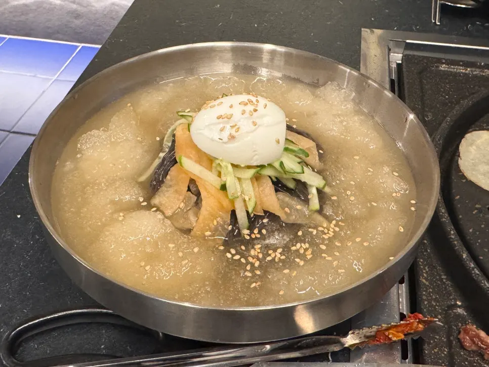 A bowl of mul-naengmyeon ordered alongside the meat
