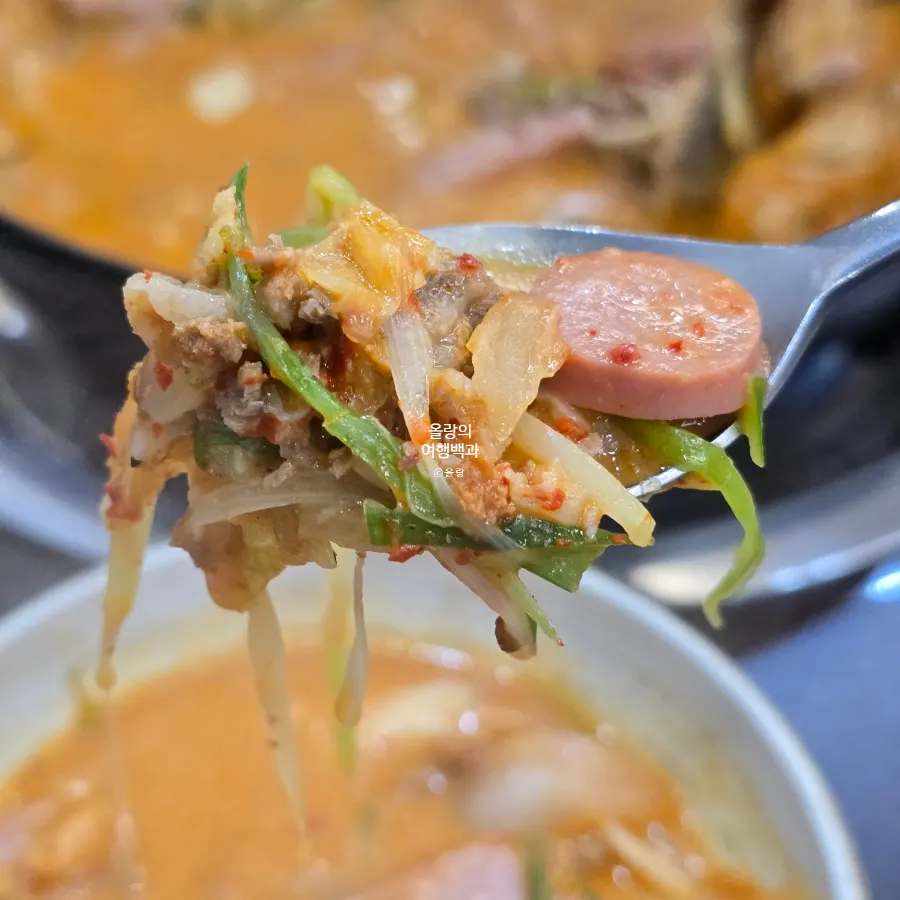 A pot of Songtan budae-jjigae topped with cheese