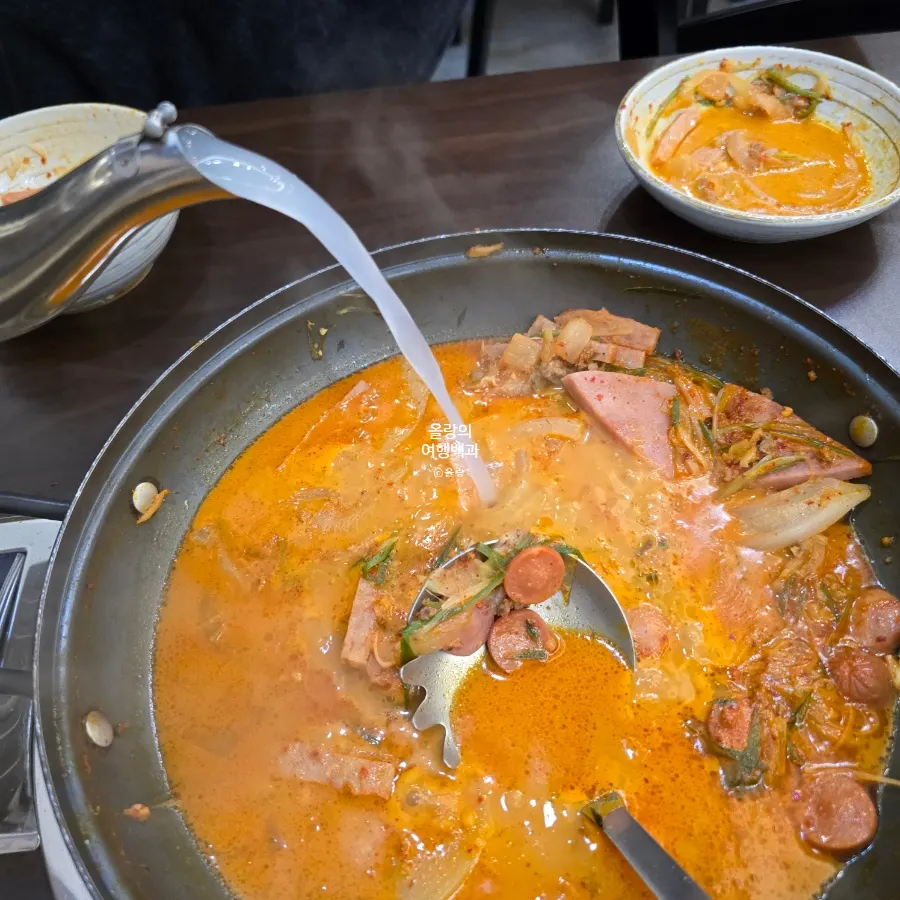 A pot of broth prepared at the table for budae-jjigae