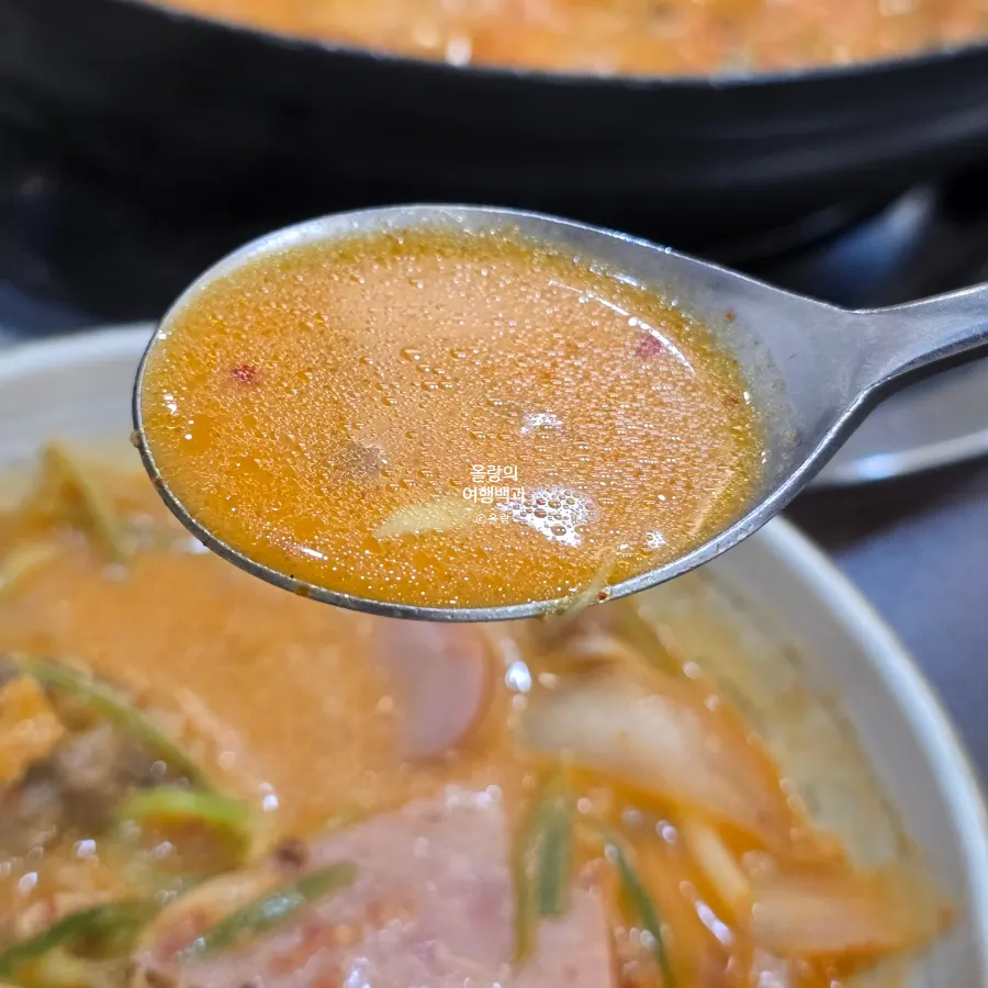 Songtan budae-jjigae broth with two slices of melted cheese