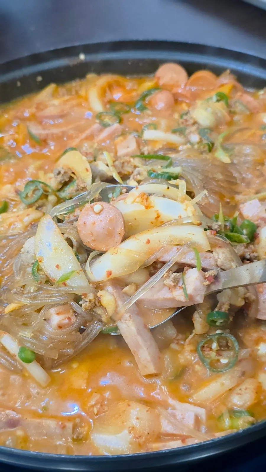 Close-up of budae-jjigae with a deepened broth