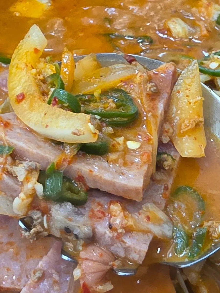 A spoonful of rice topped with broth