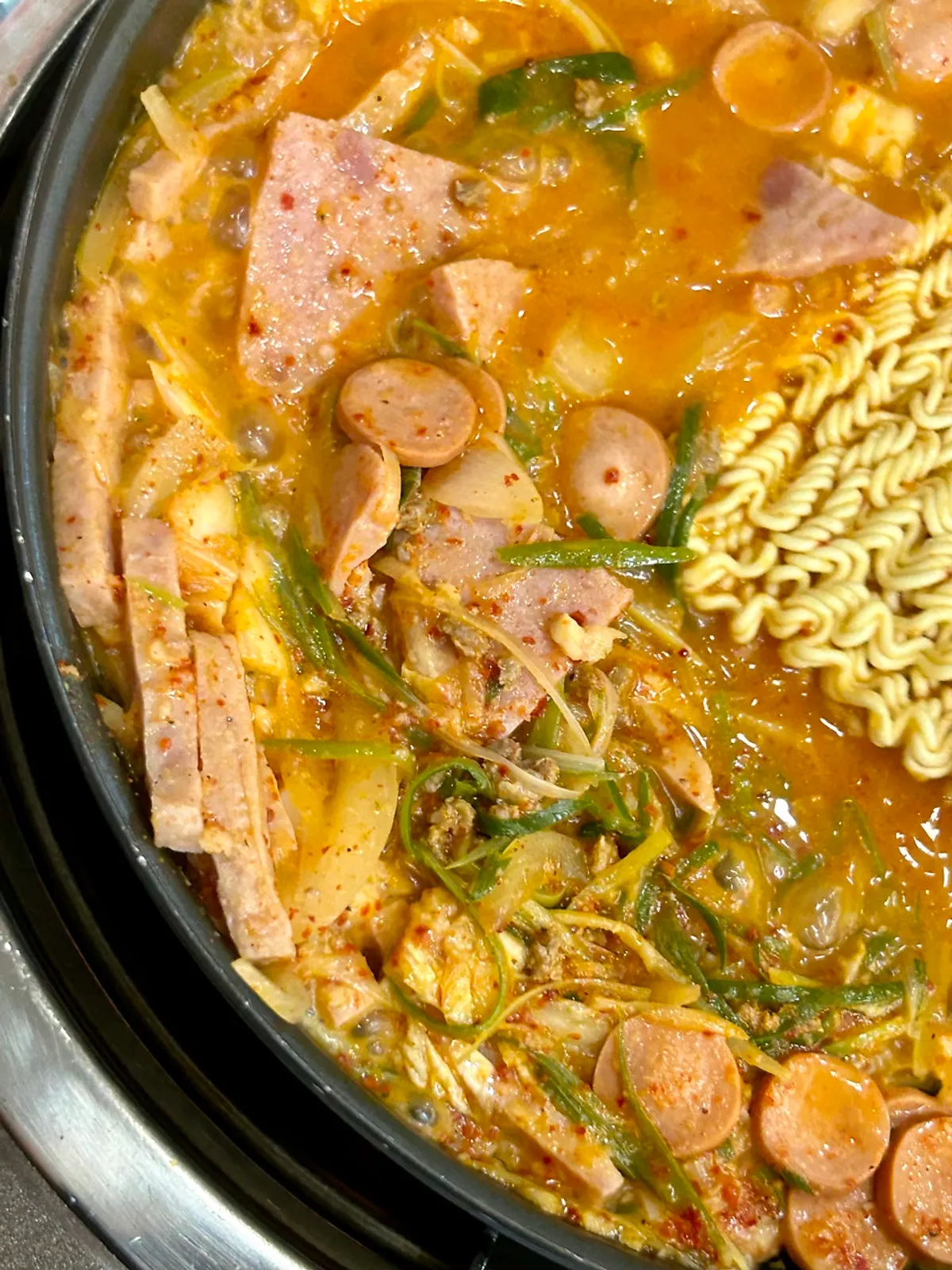 Songtan budae-jjigae at a rolling boil with ramyeon noodles added