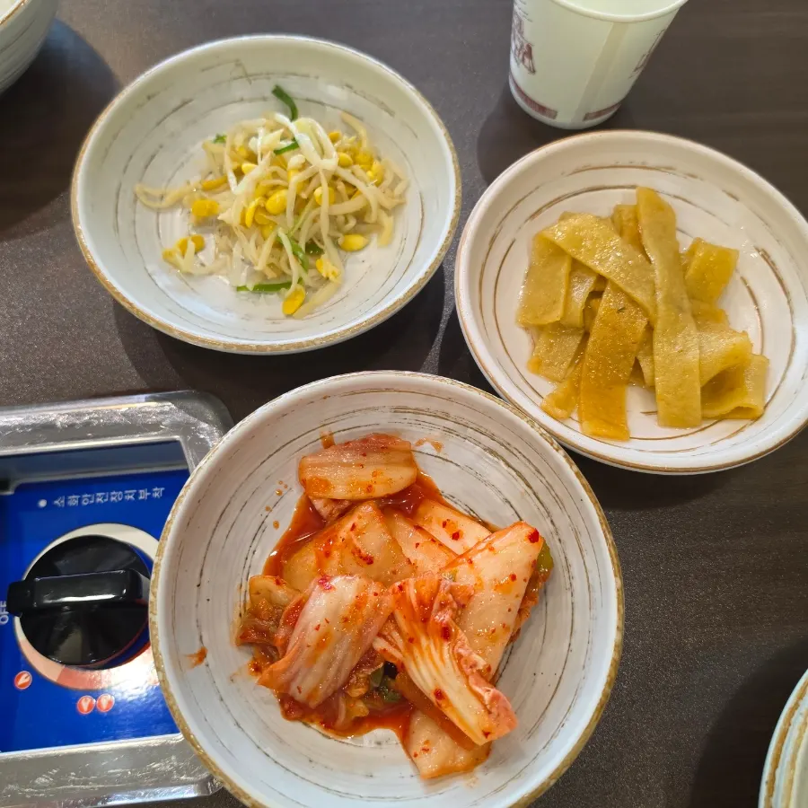 Three basic side dishes: bean sprout salad, stir-fried fish cake, and napa cabbage kimchi