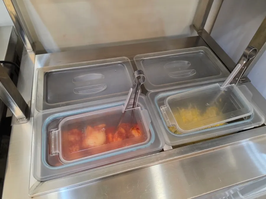 Lidded container of noodle toppings at the self-serve bar