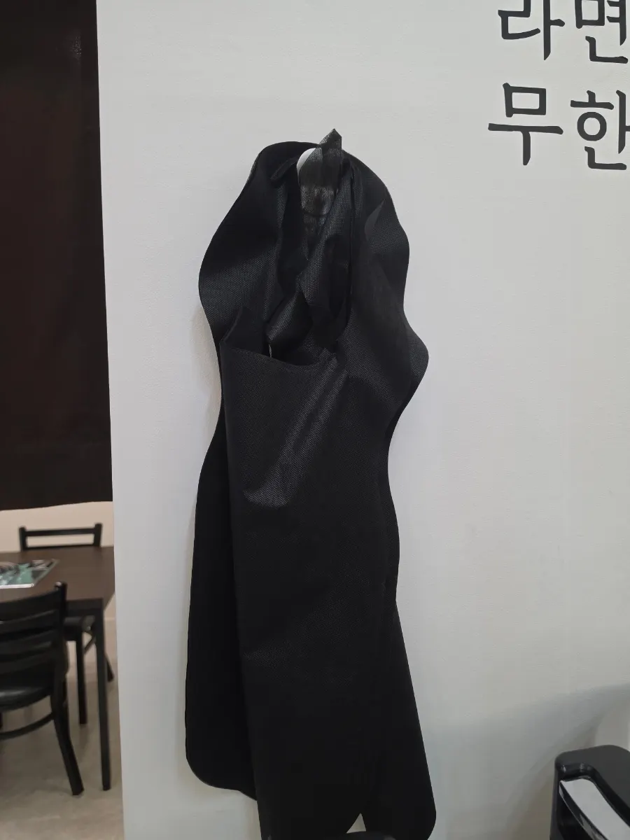 Black disposable aprons next to the self-serve bar