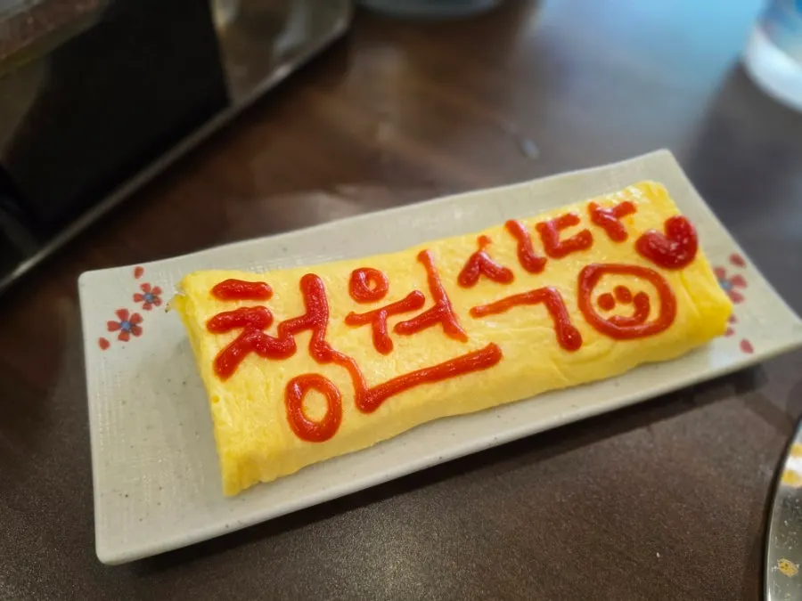 A thick egg roll with the restaurant's name written in ketchup