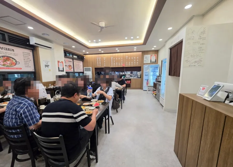 우드 톤 테이블이 놓인 청원식당 홀 내부