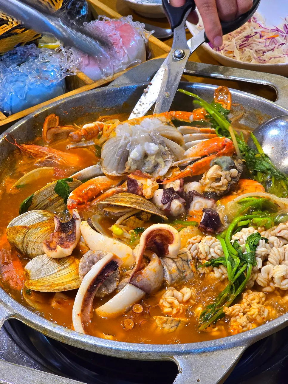 打开锅盖调整火候的海鲜汤食材