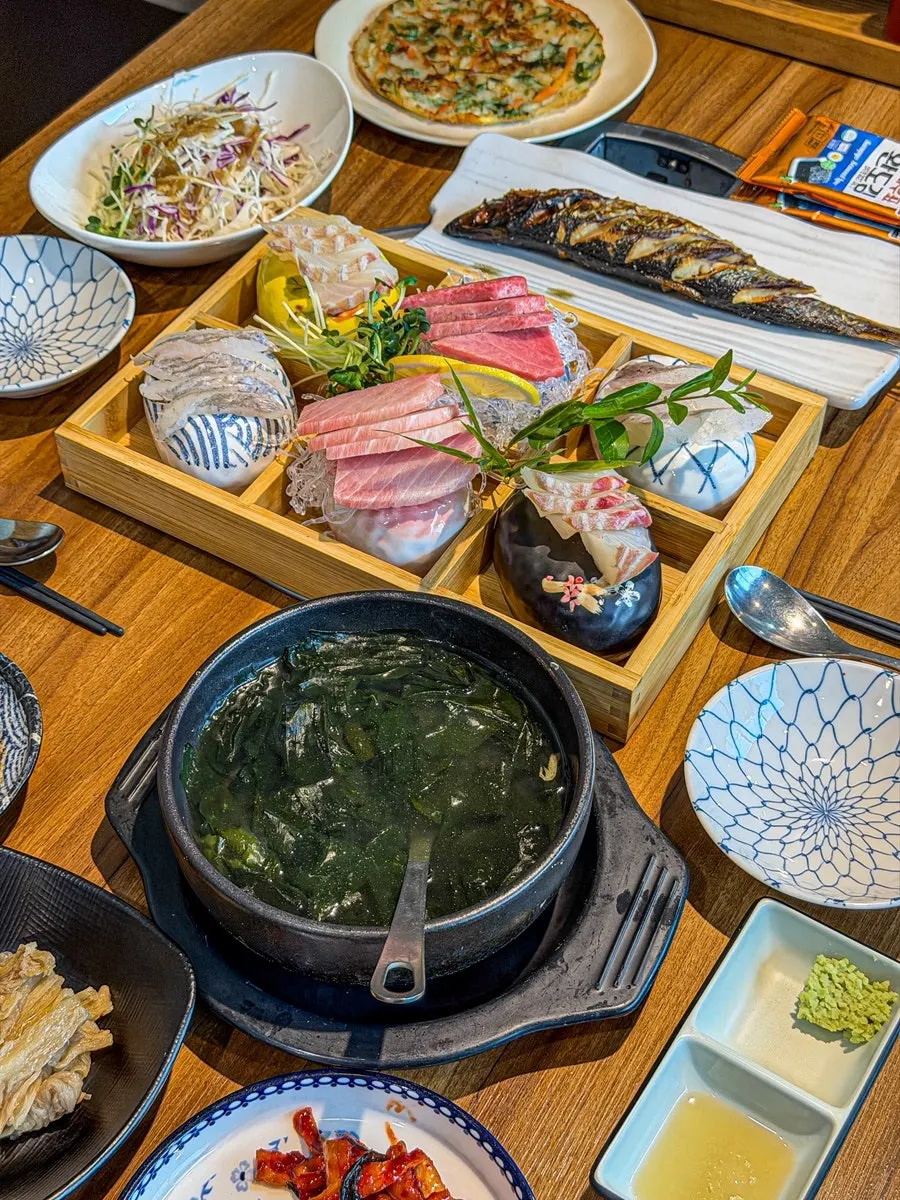 Table set with the sashimi platter and seafood stew set for two