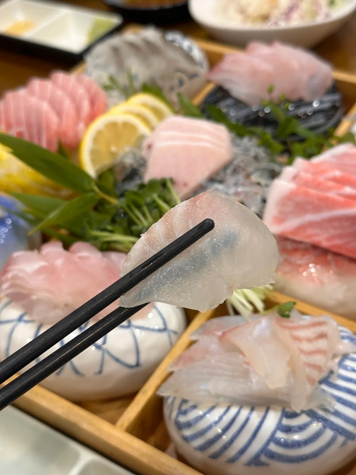 Thickly sliced sashimi with radish sprouts and lemon