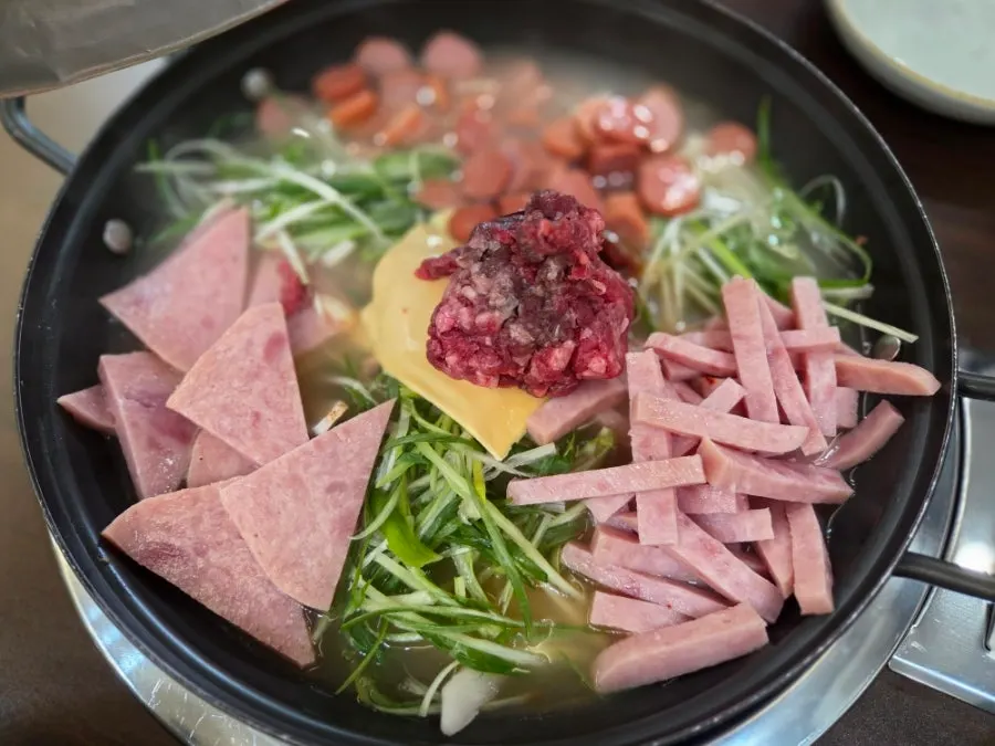 Songtan budae-jjigae topped with ham and cheese