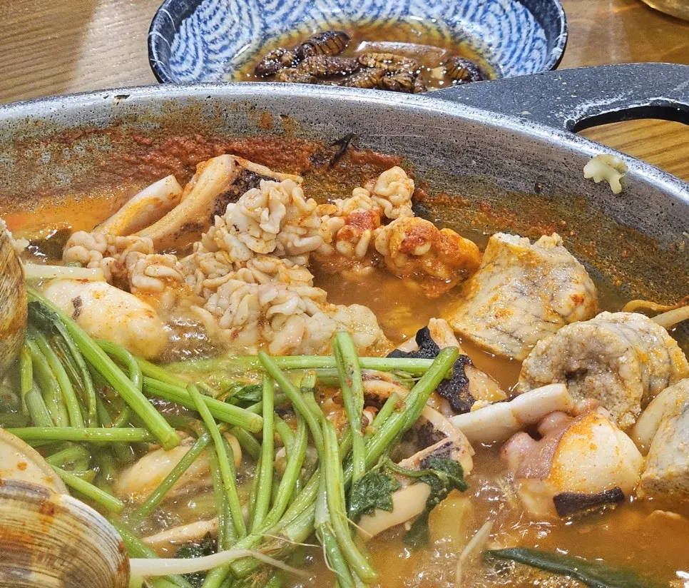 Spicy seafood stew topped with minari