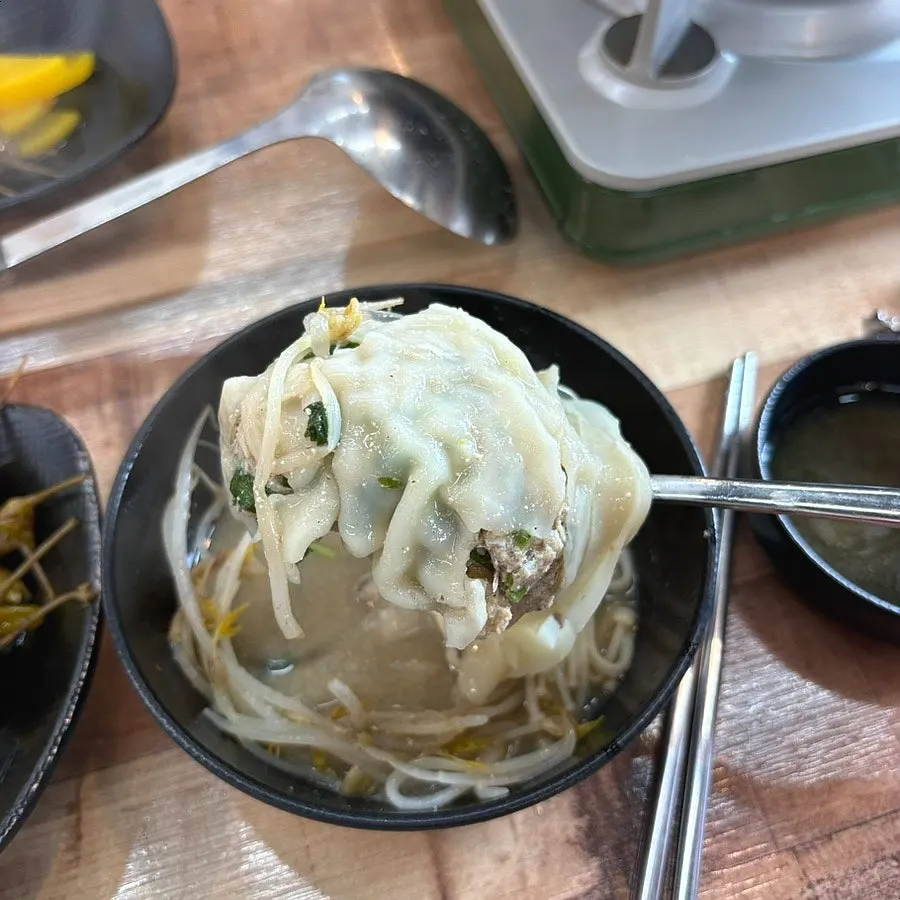 しんなりした野菜と肉をすくって食べる様子