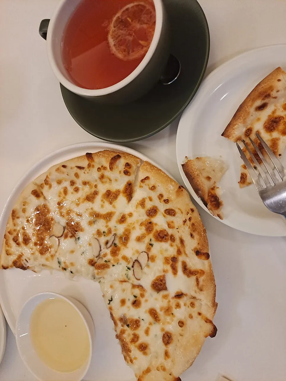 A slice of gorgonzola pizza served with honey