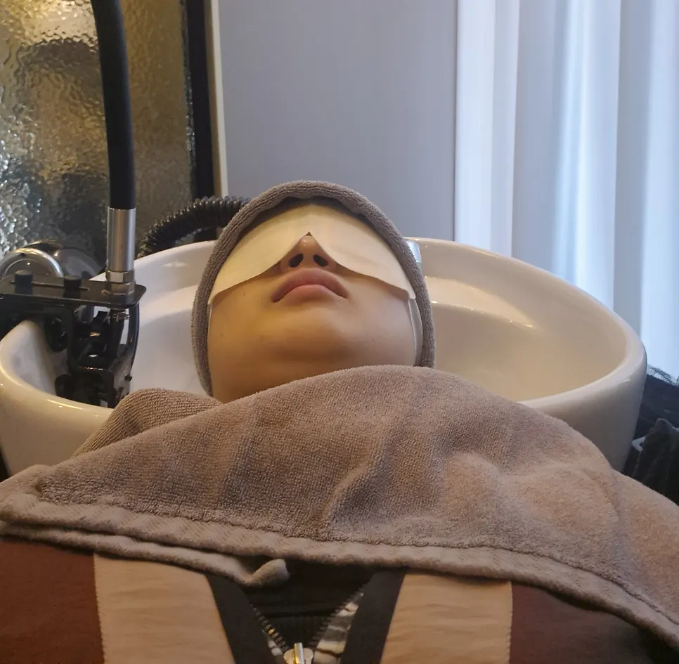 Scalp care beginning with a warm eye mask placed on