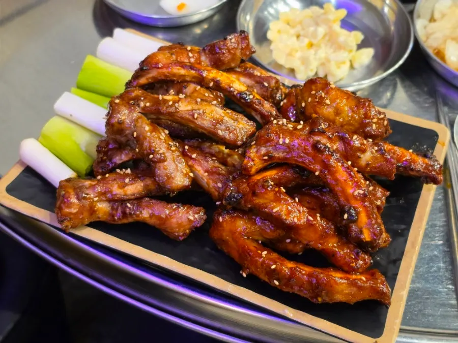 Spicy and barbecue jjokgalbi on the grill with sliced green onions