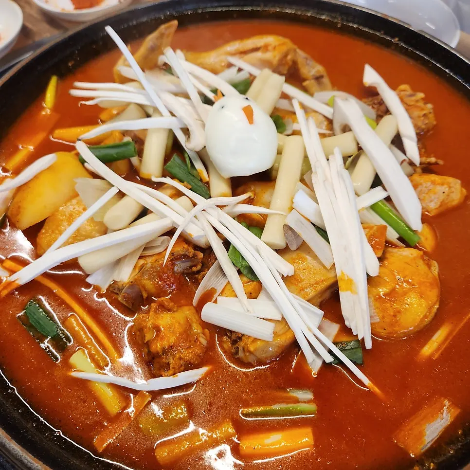 솥뚜껑 위에서 끓고 있는 닭 한마리 닭볶음탕