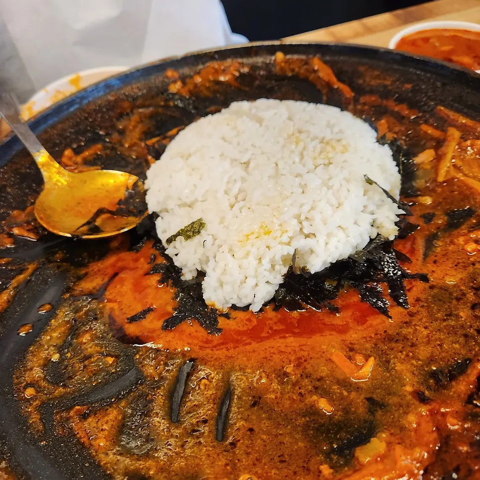 남은 양념에 밥과 김가루를 넣어 볶는 모습