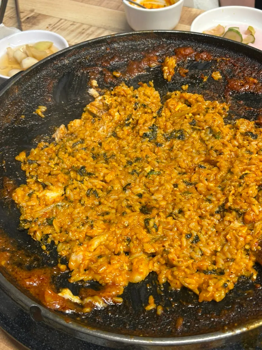 Fried rice being stirred with two spatulas