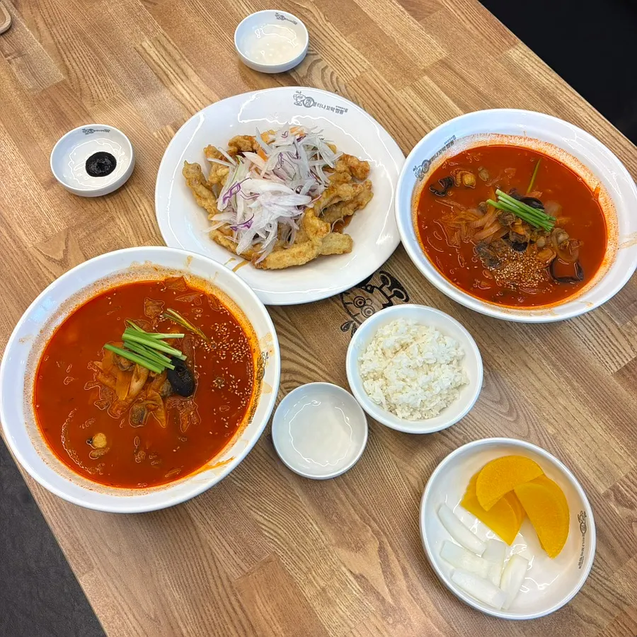 Table set with level 2 and level 4 cockle jjamppong and a small sweet and sour pork