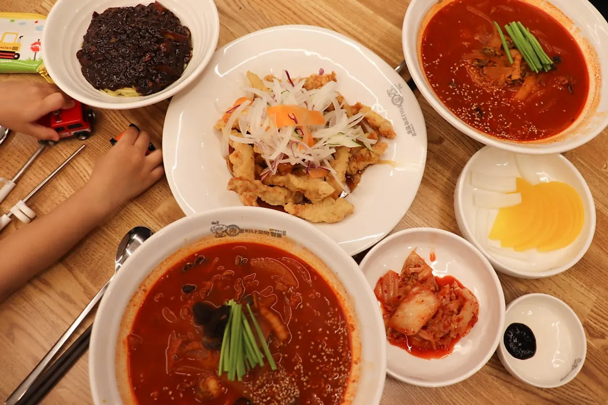 A spread of cockle jjamppong, sweet and sour pork, and kids' jjajang