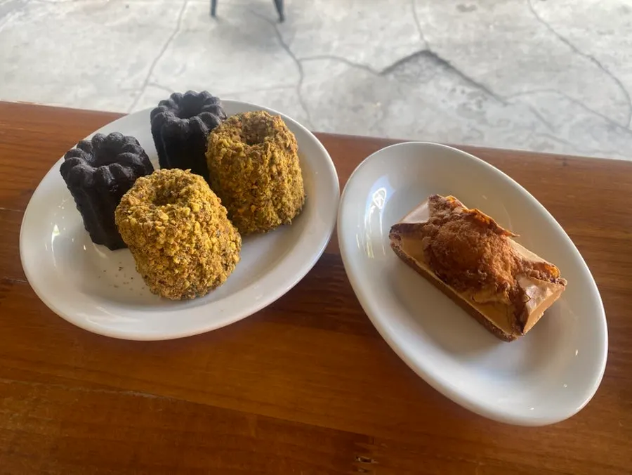 Three pastries — canelé and financier — placed on the table