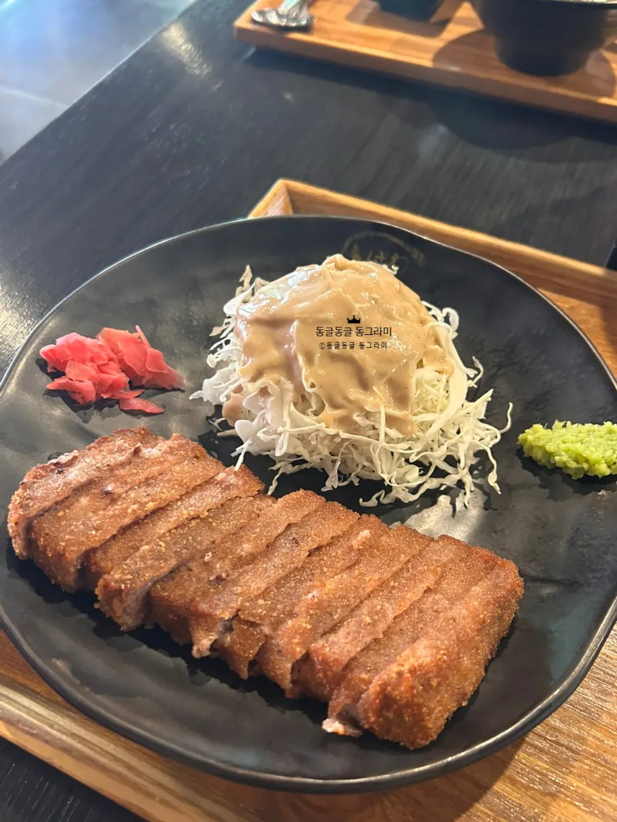 A piece of gyukatsu grilling on the mini charcoal stove