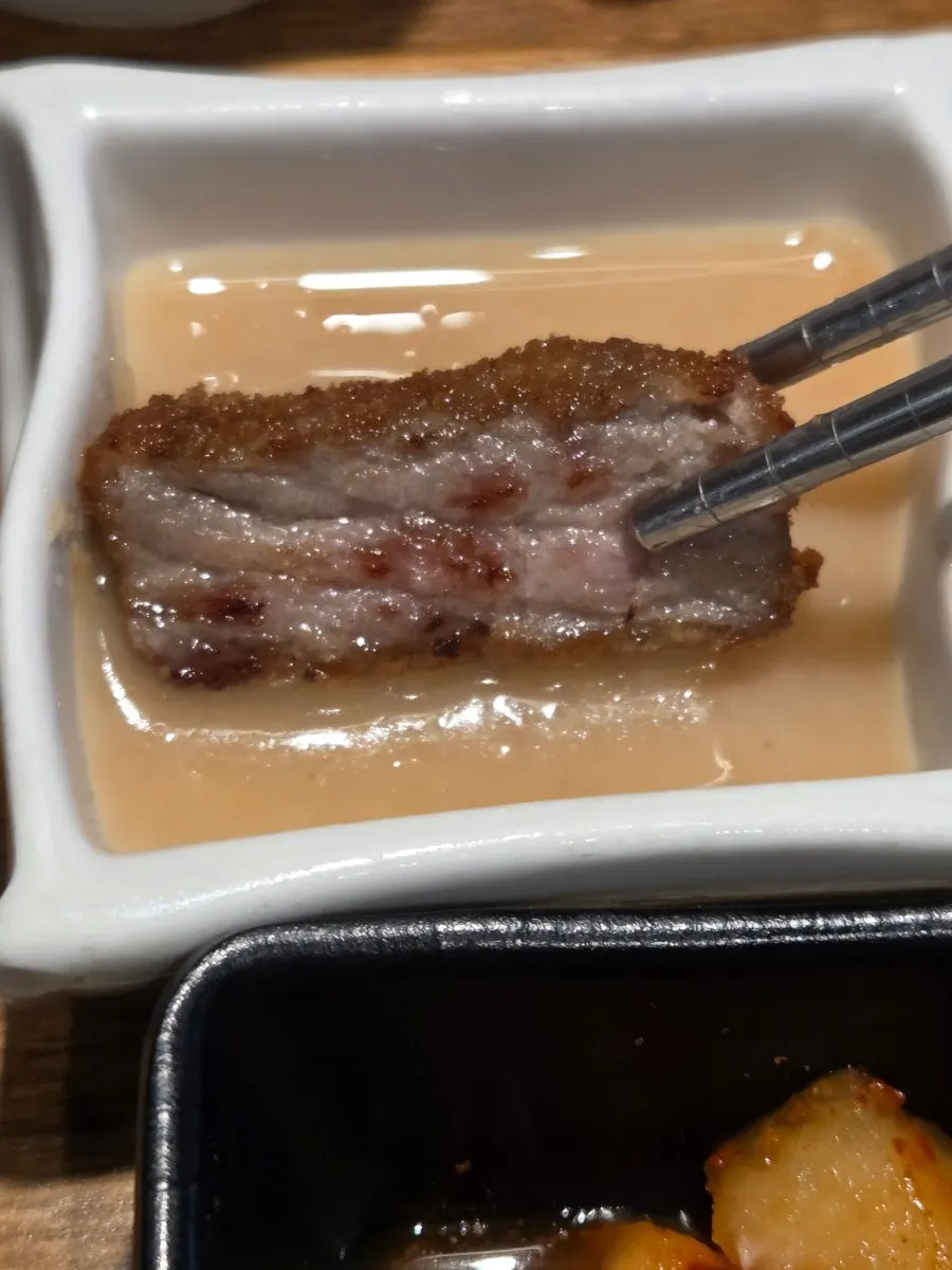 A piece of gyukatsu topped with wasabi